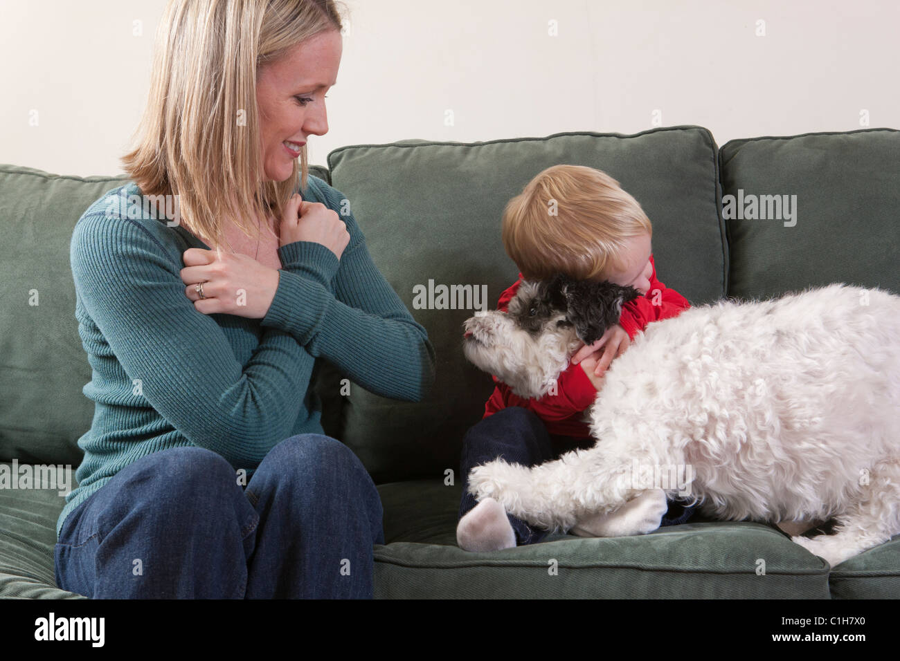 Unterzeichnen das Wort "Umarmung/Love" in amerikanischer Gebärdensprache mit ihrem Sohn umarmt einen Hund Frau Stockfoto