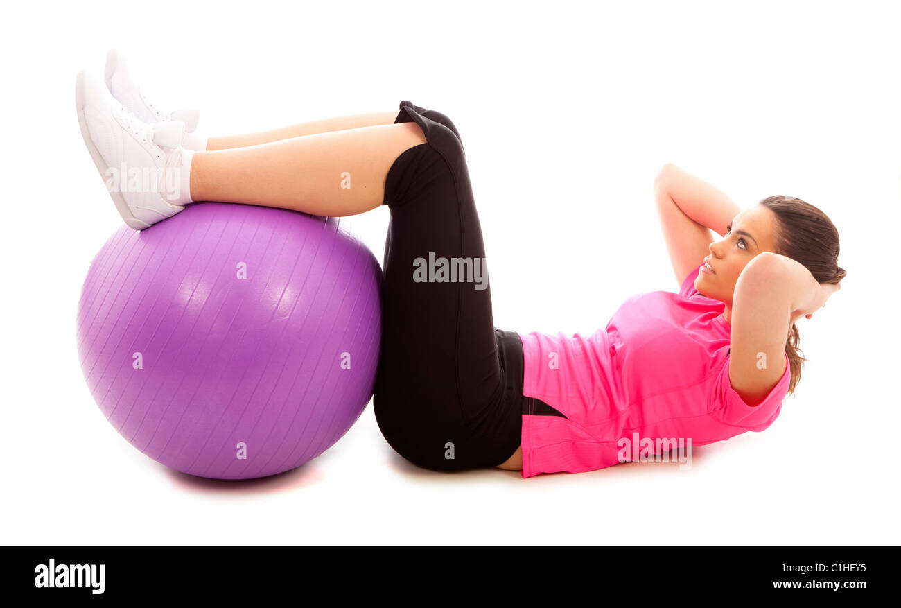 Eine junge Frau tut ein Bauch crunch mit einem lila Gymnastikball Stockfoto