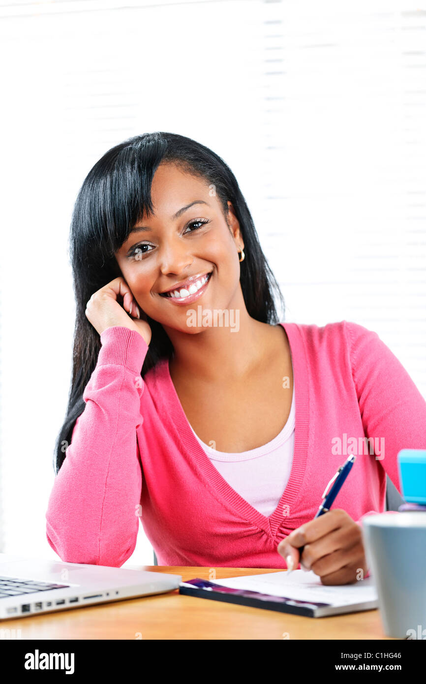 Porträt von lächelnden jungen schwarzen Studentin Studium an der Rezeption Stockfoto