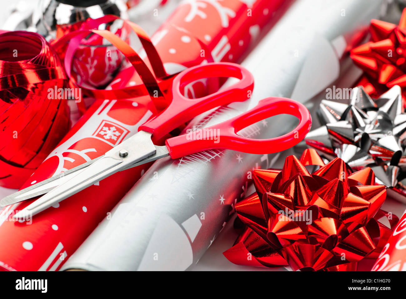 Rollen Weihnachten Geschenkpapier mit Bändern, Schleifen und Schere Stockfoto