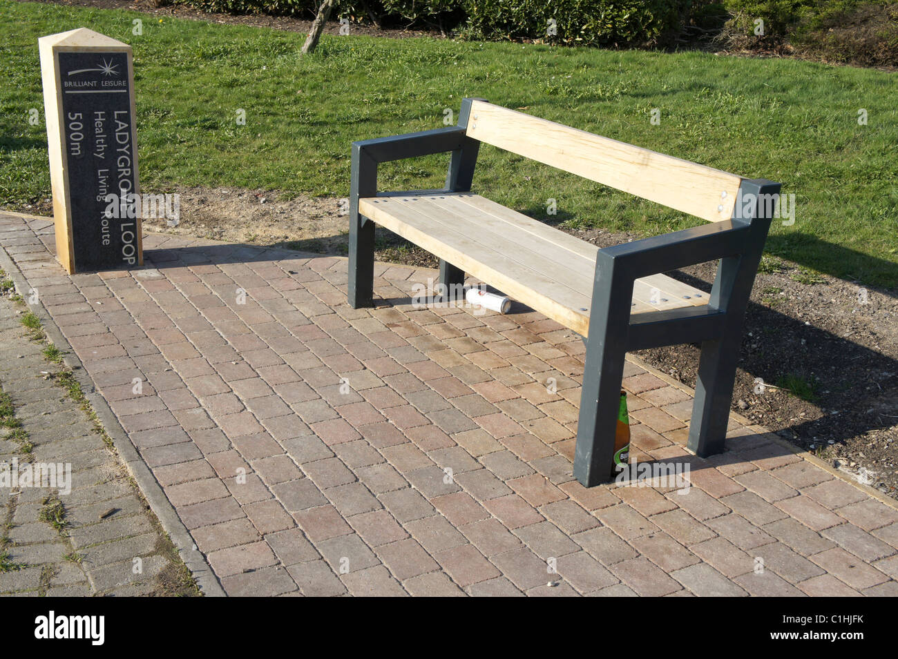 Ladygrove Schleife, Didcot, Oxfordshire, gesund Leben-Route, Park bench mit Bierflasche und können. Anti-soziales Verhalten. Stockfoto