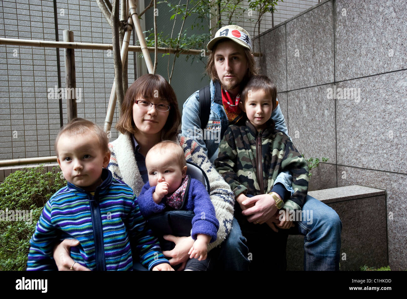 Alastair Dixon (2R), warten 30 von Cambridgeshire und seine Familie auf den letzten Bus aus Sendai, Japan Stockfoto