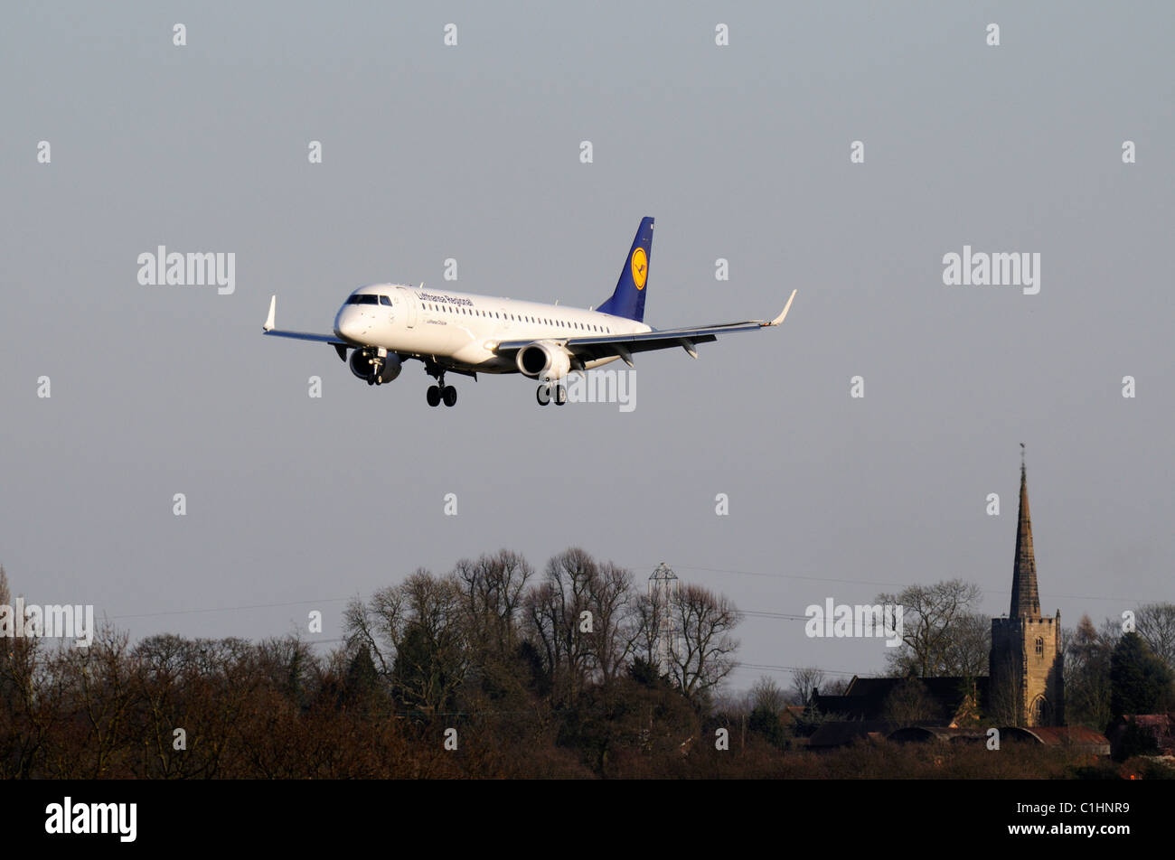 Lufthansa Regional Embraer 190 Birmingham internationaler Flughafen mit Bickenhill Kirche im Hintergrund Stockfoto