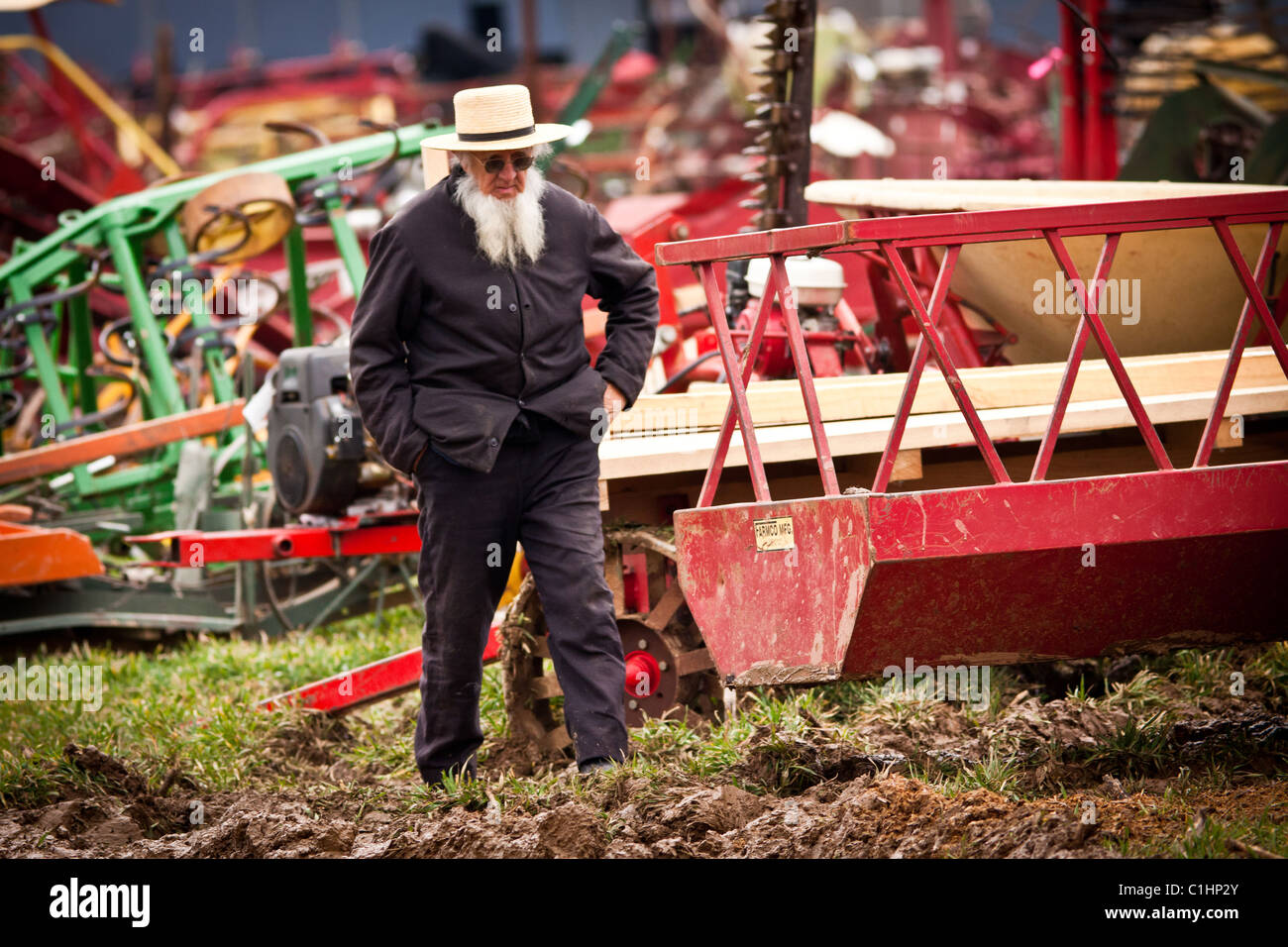 Älterer Amish Mann geht vorbei an Landmaschinen während des jährlichen Schlamm Verkaufs zur Unterstützung der Feuerwehr in Gordonville, PA. Stockfoto
