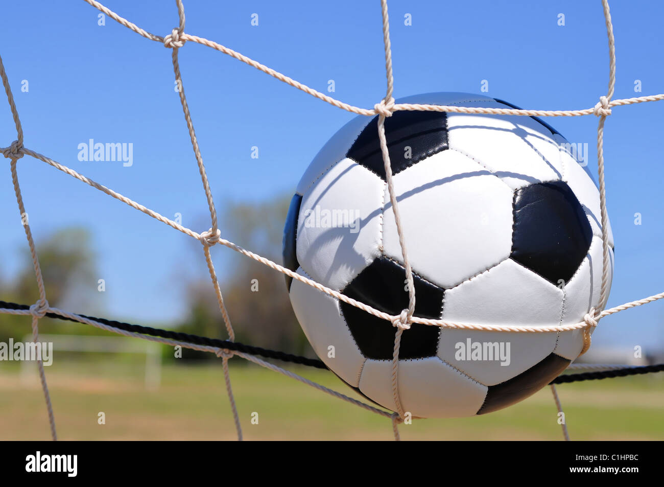 Fußball im Netz des Tores mit Textfreiraum. Stockfoto