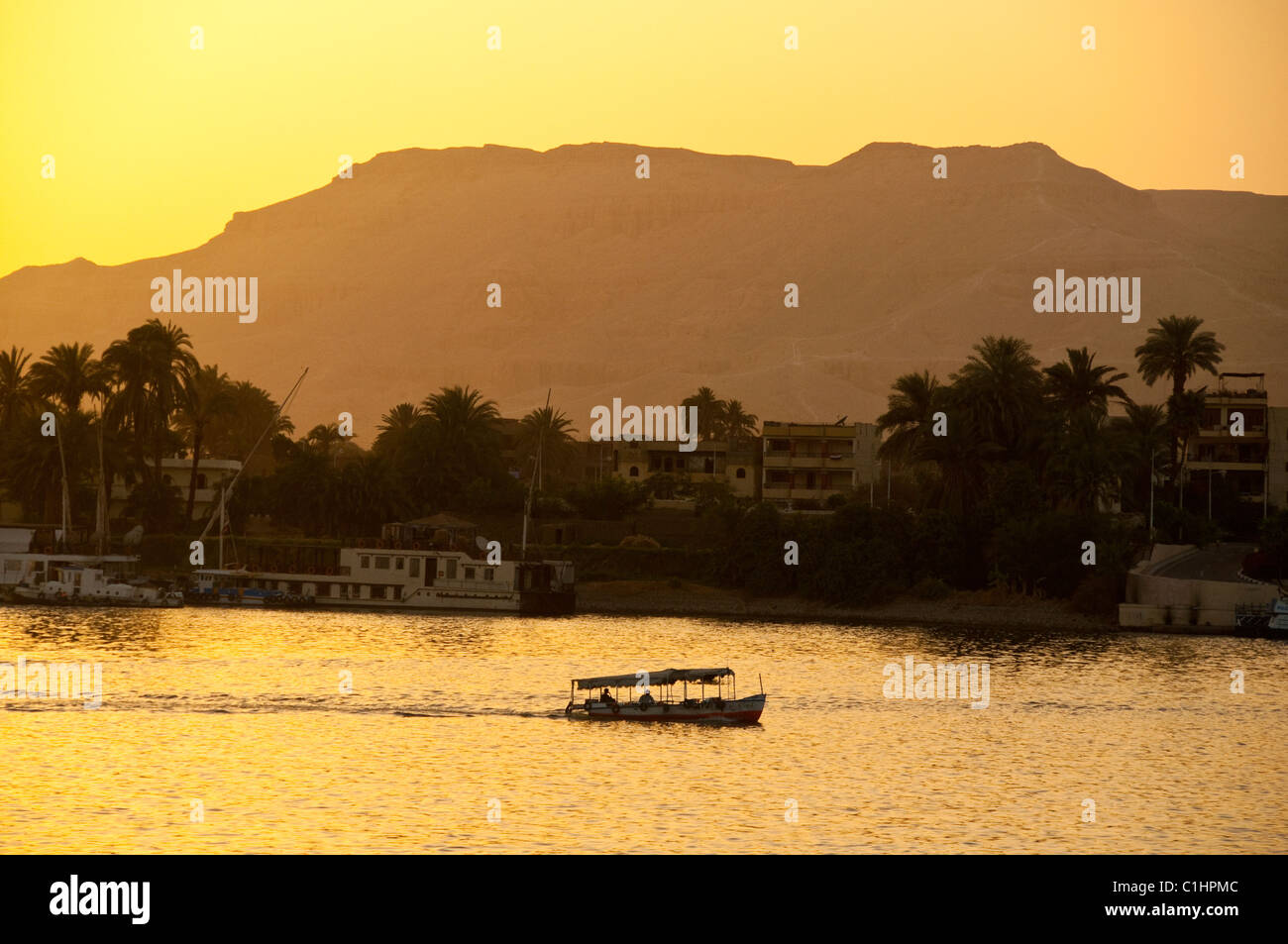 Einem traditionellen ägyptischen Feluke Boot segelt auf dem Nil in Luxor, Ägypten mit einer Personenfähre vorbei. Stockfoto