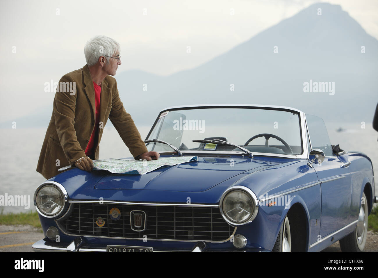 Senior woman Cabrio am Meer, Italien Stockfoto