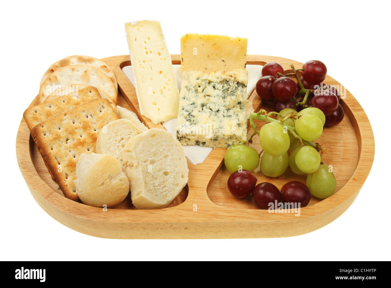 Käse vom Brett mit Trauben, Brot und Gebäck Stockfoto