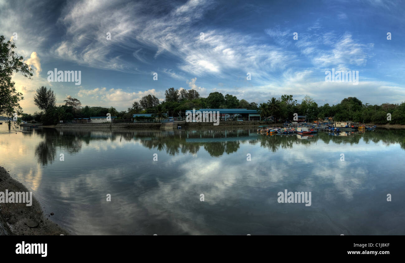 Ein großer Fluss in der Nähe des Strandes. Reflexion der Wolken am Himmel und Landschaft am Horizont waren auch im Wasserkörper erfasst. Stockfoto