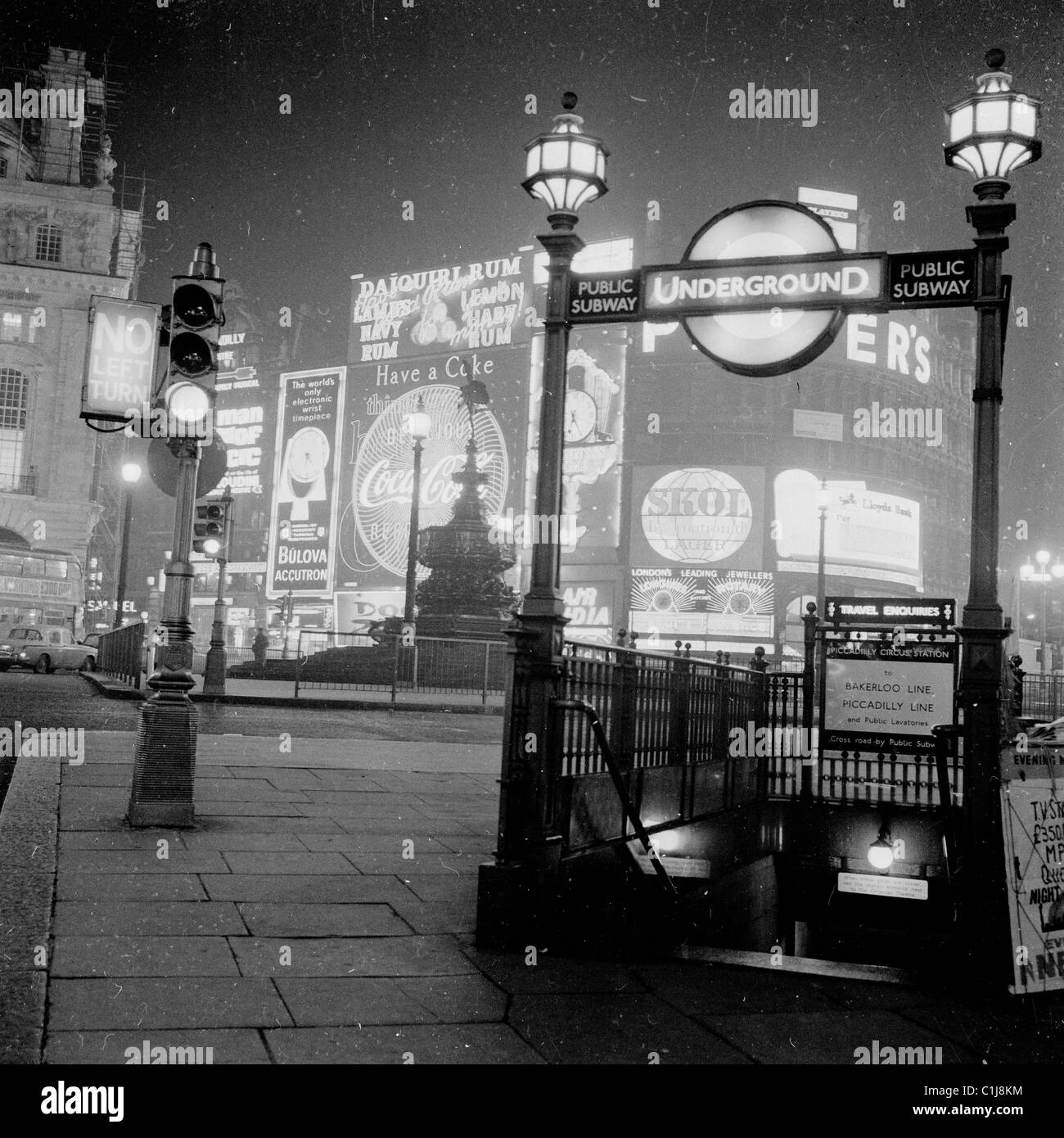 Die 1950er Jahre, die Geschichte, die Abendzeit und die Neonwerbetafeln am Piccadilly Circus, London, beleuchten das berühmte Wahrzeichen des West End. Stockfoto