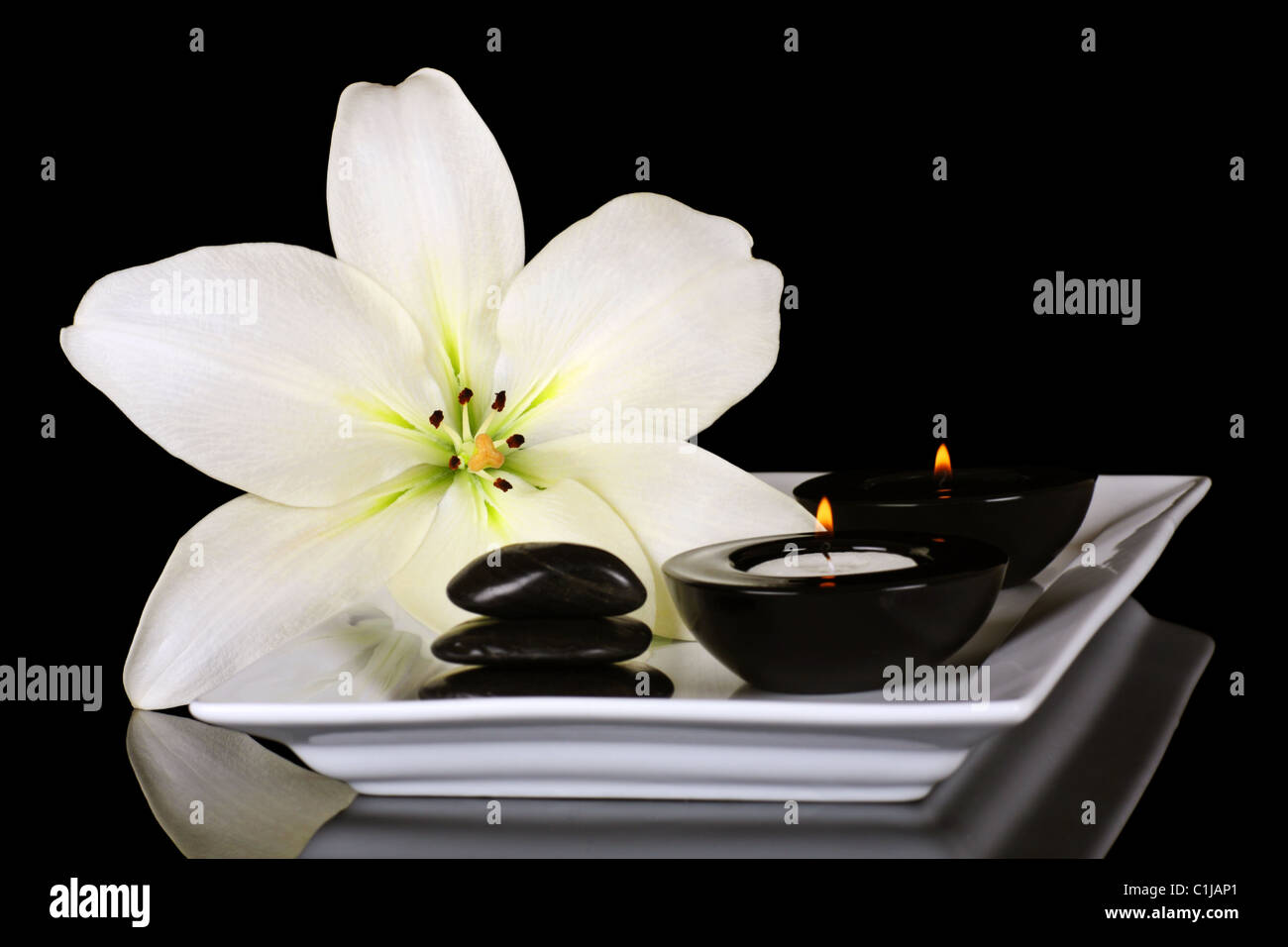 Aromatherapie Kerzen mit einer schönen Lilie, eine beruhigende Art und Weise zu entspannen. Stockfoto