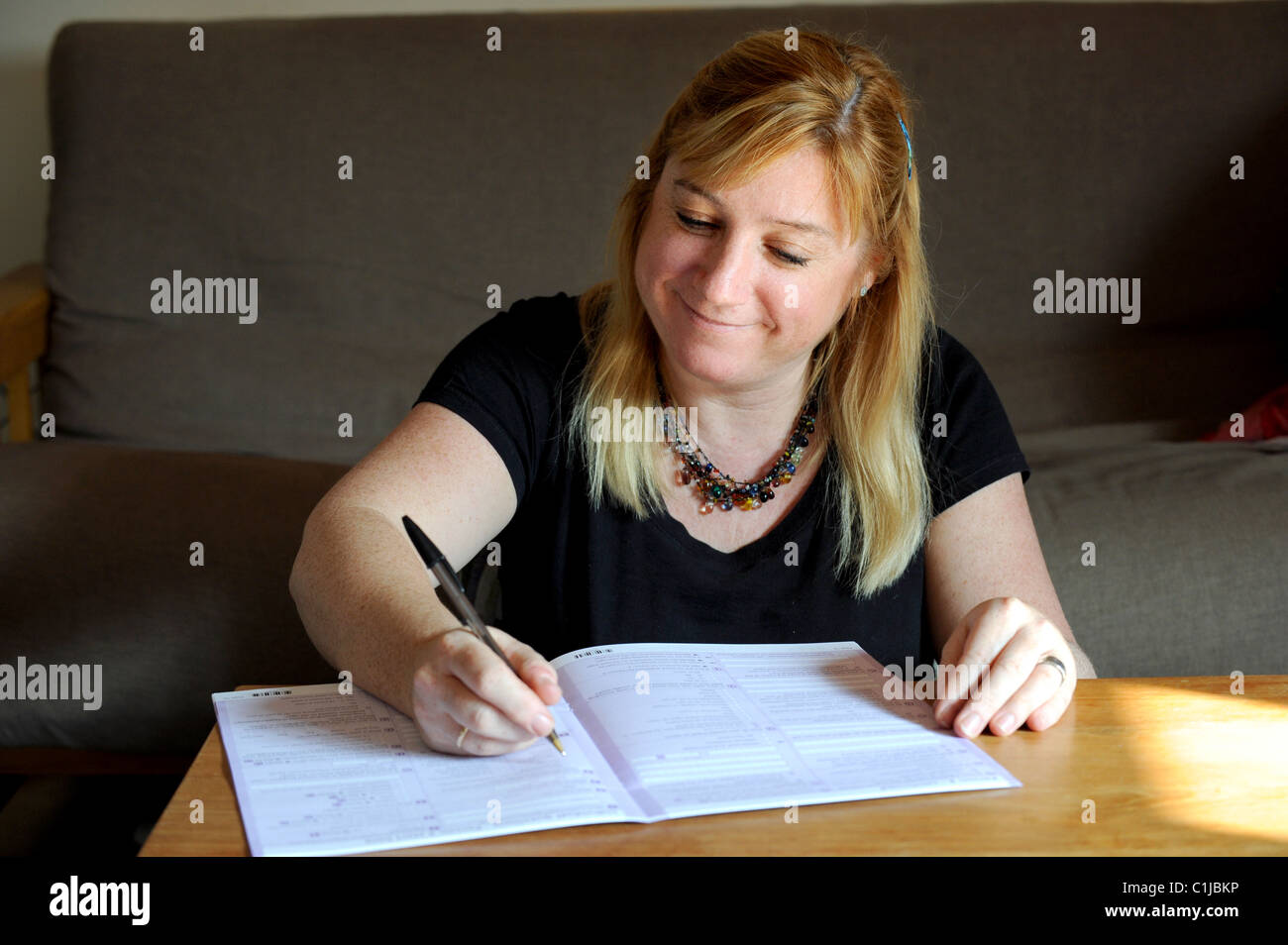 Eine Frau Ausfüllen des Zensus-Formulars UK 2011 zu Hause Stockfoto