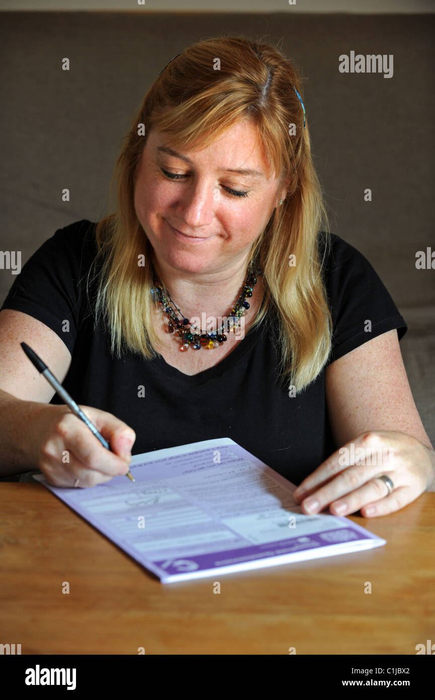 Eine Frau Ausfüllen des Zensus-Formulars UK 2011 zu Hause Stockfoto