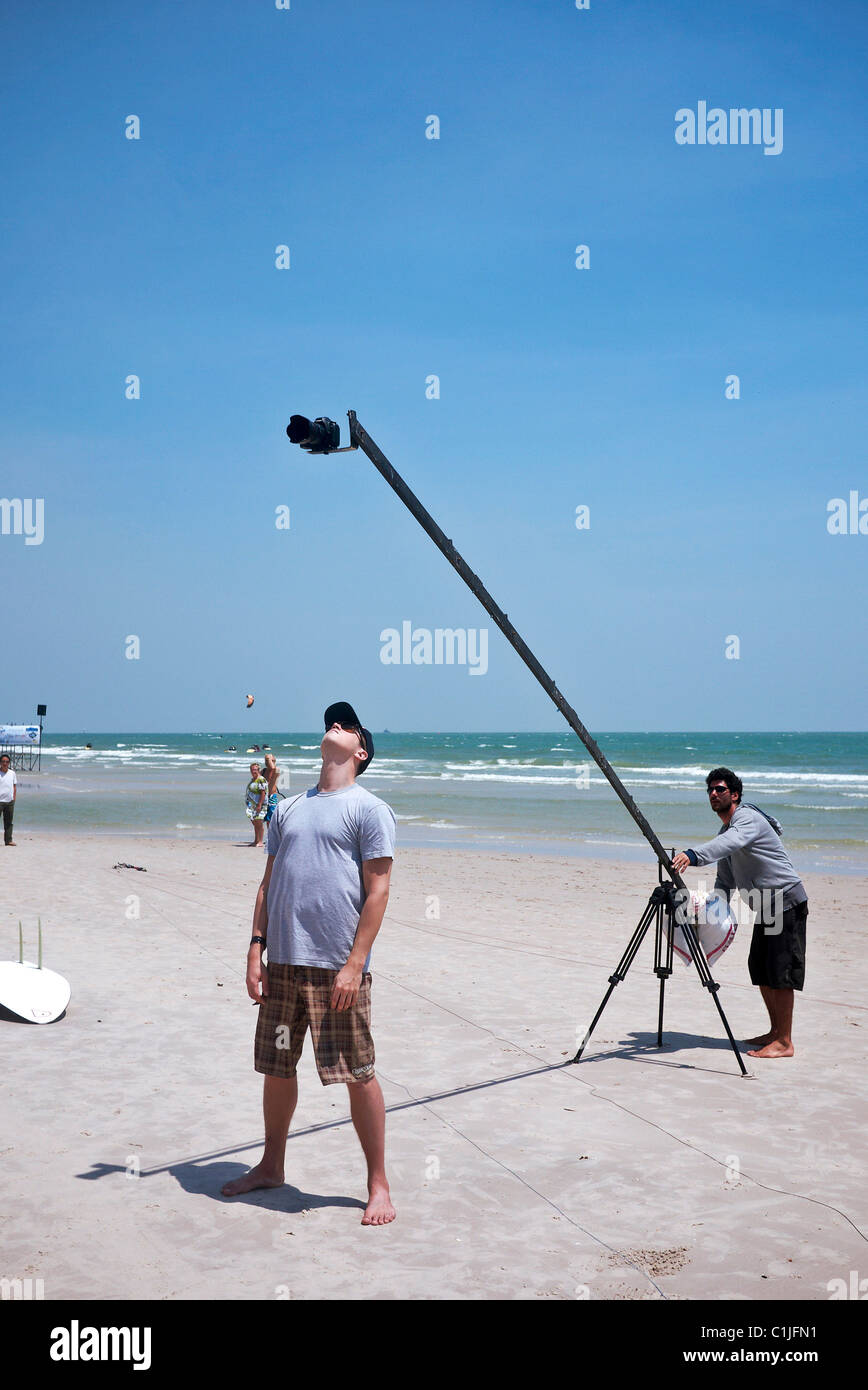 Kameraarm. Der Strandfotograf nutzt einen Kameraausleger, um einen erhöhten Blick auf ein lokales Kite-Boarding-Sportereignis zu erhalten. Außenfotograf vor Ort Stockfoto