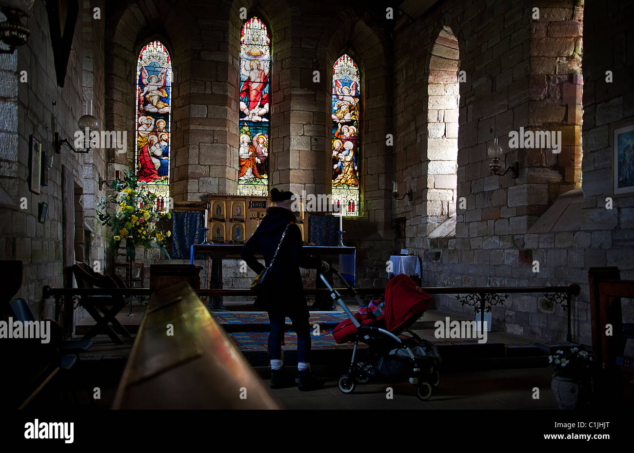 Junge Mutter und Kind, die das Innere des St Marys Jungfrau bewundern. Heilige Insel Lindisfarne. Northumberland.UK Stockfoto