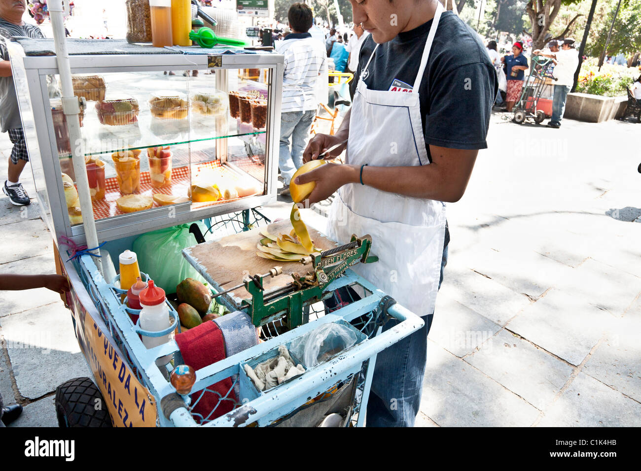 Obstverkäufer steht über seinem Karren peeling eine Mango in Oaxaca Zocalo-Mexiko Stockfoto