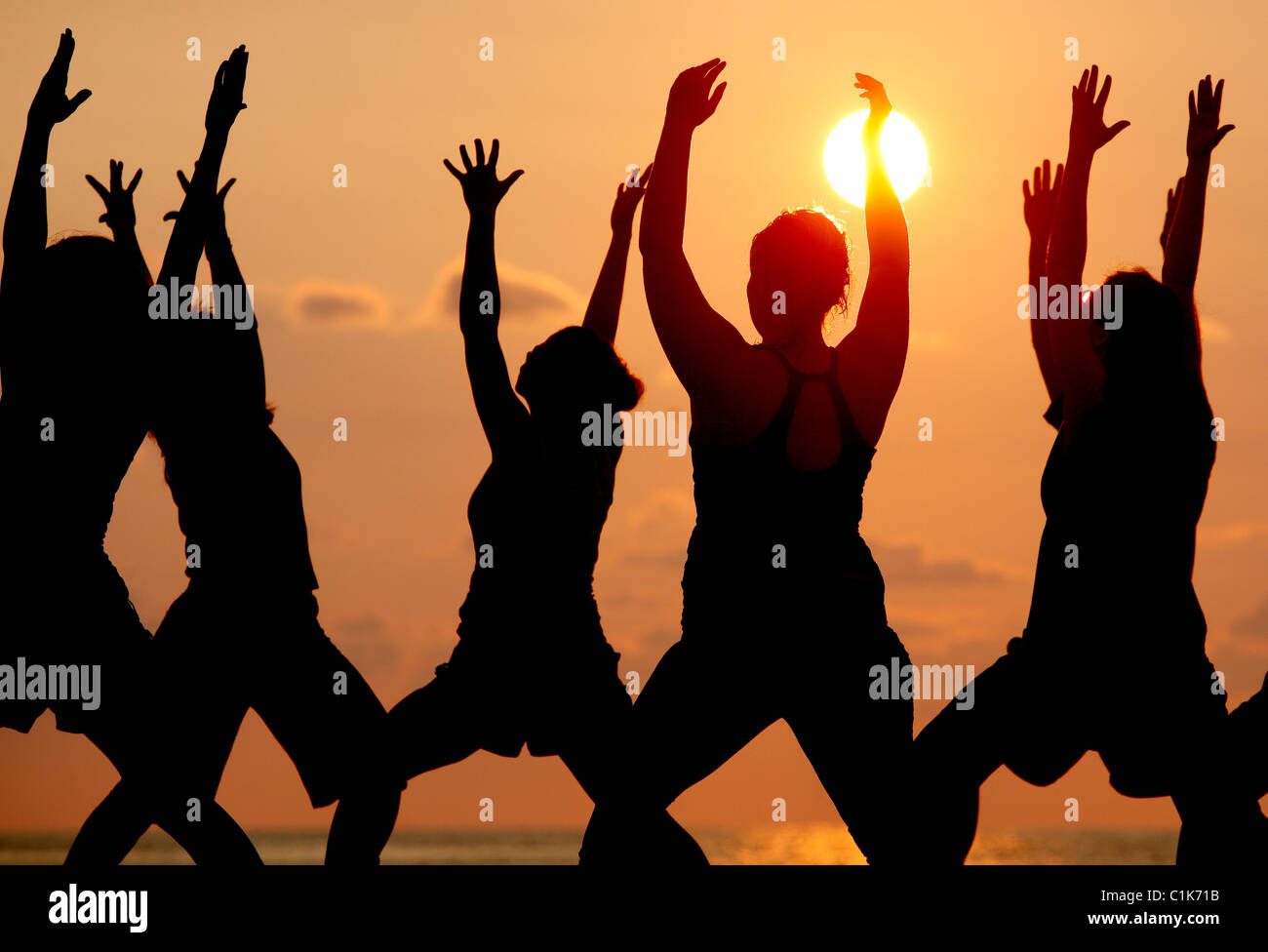 Eine Gruppe von Menschen praktizieren Yoga am Strand bei Sonnenuntergang, Jaco, Costa Rica Stockfoto
