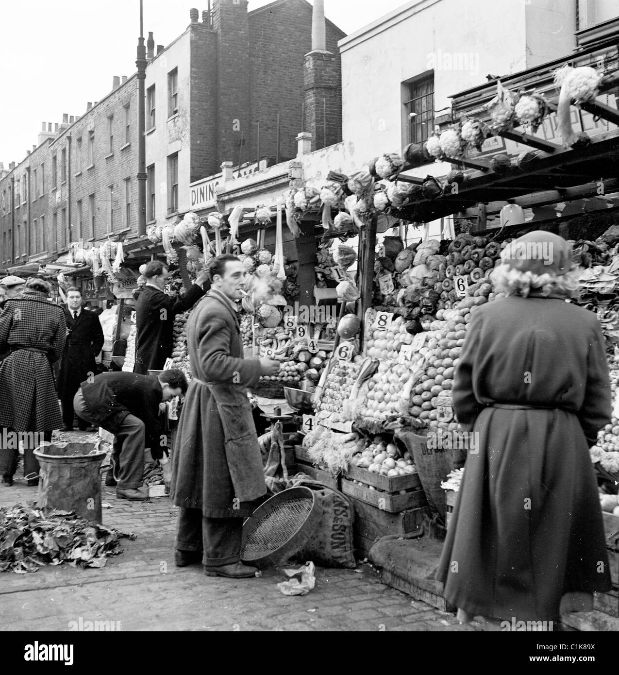 1950er Jahre, ein Foto von J Allan Cash von einem Händler an seinem Obst- und Gemüsestand auf dem Outdoor-Markt in Camden Town, London. Stockfoto