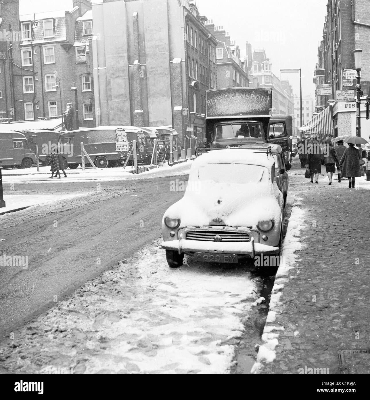 1950er Jahren Winterzeit, London und ein Auto geparkt an einer Nebenstraße, bedeckt mit Schnee in diesem historischen Bild von J Allan Cash. Stockfoto