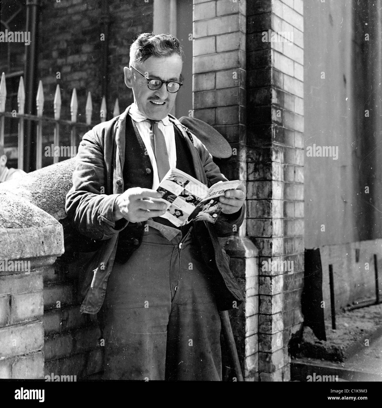 1950er Jahre historische Bild von J Allan Cash von einen älteren männlichen Träger am viktorianischen Bahnhof eine Pause. Stockfoto