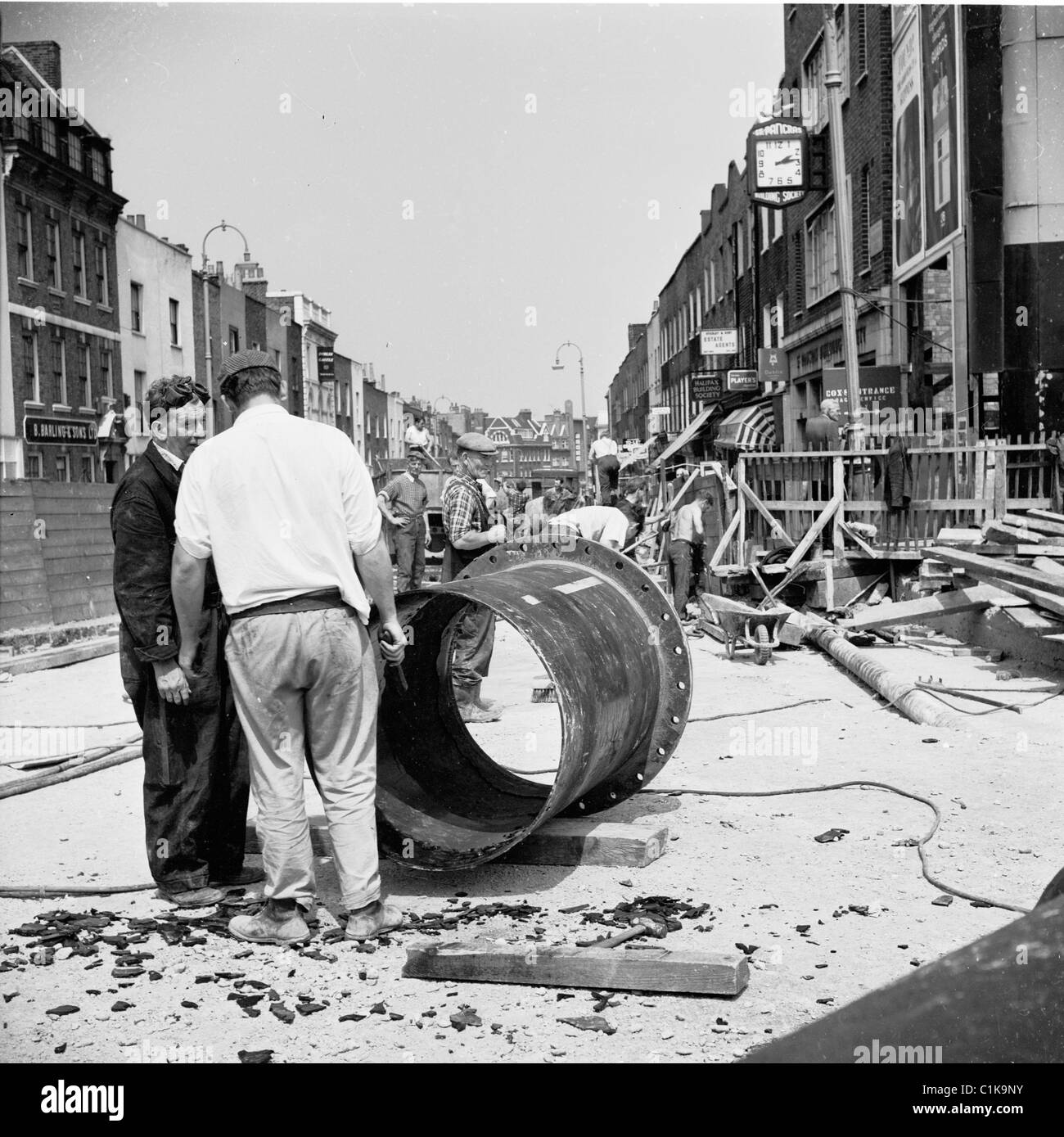 1950er Jahre London. In diesem historischen Bild von J Allan Cash haben zwei männliche Arbeitnehmer eine Diskussion auf einer Baustelle. Stockfoto