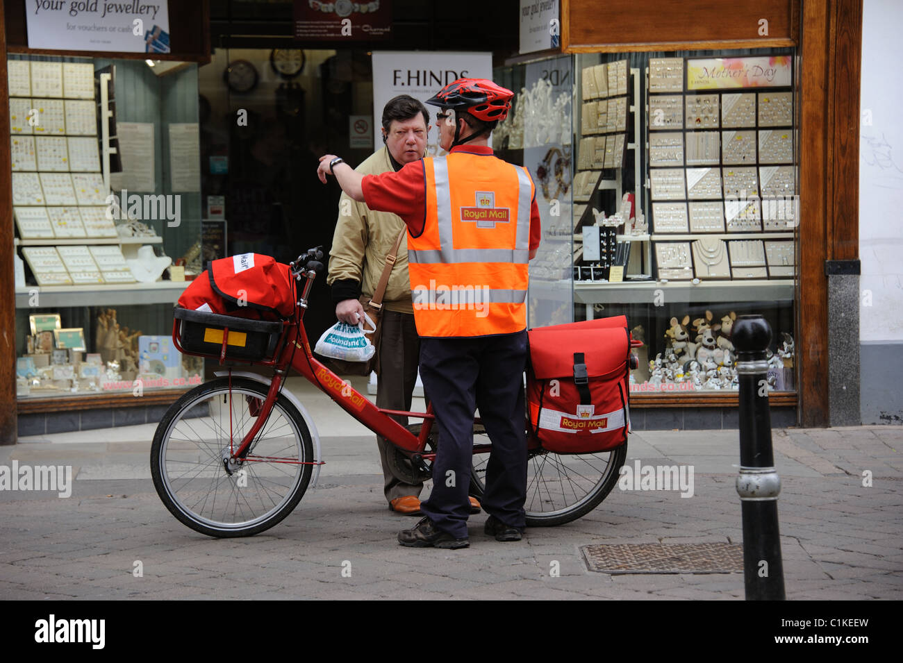 Postbote mit dem Fahrrad, die Erteilung von Anweisungen an ein Passant auf seinem Stadtzentrum Runde Stockfoto