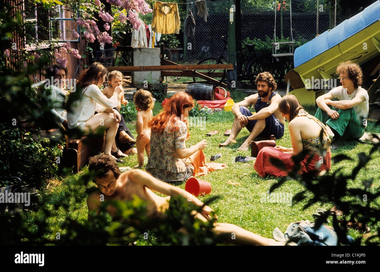 Hippie-Hippies Mitglieder einer Hippie-Gemeinde aus den 1970er 70er Jahren sitzen zusammen mit Kindern zu Hause in einem städtischen Camberwell Gemeinschaftsgarten in der Hitzewelle von 1976 im Sommer 76 (Sommer 1976) South London England Großbritannien KATHY DEWITT Stockfoto