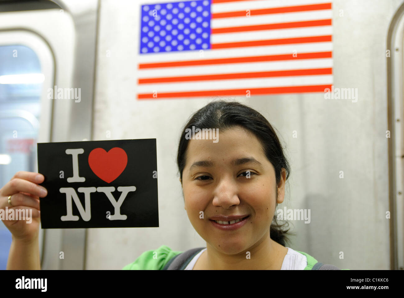 Hispanic - asiatische Frau, die mit "I Love New York" Postkarte, U-Bahn u-Bahn Bahnhof, New York City Stockfoto