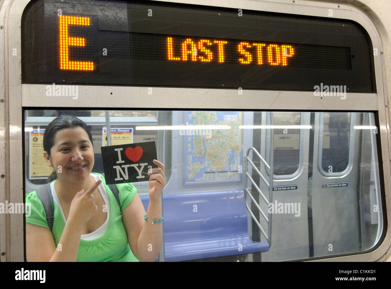 Hispanic - asiatische Frau, die mit "I Love New York" Postkarte, U-Bahn u-Bahn Bahnhof, New York City Stockfoto