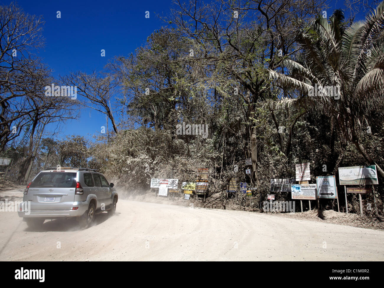 Ein 4 x 4 Fahrzeug übergibt Hotel und Lodge Zeichen auf einem staubigen Feldweg in der Nähe von Ostional an der Westküste der Halbinsel Nicoya, Costa Rica Stockfoto