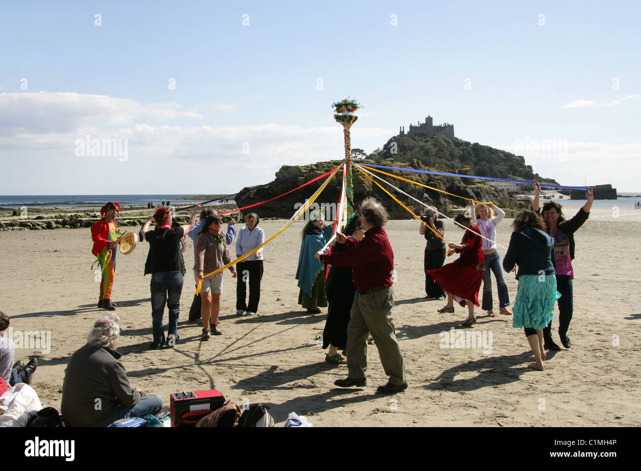 Tanz um den Maibaum. Eine alte heidnische Fruchtbarkeit Feier am Strand vor St. Michaels Mount durchgeführt wird. Stockfoto