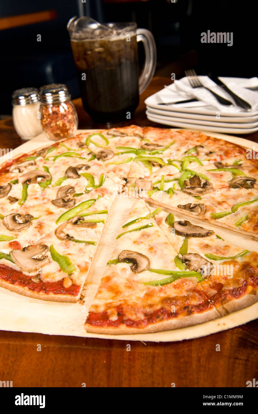 Familiengröße Pizza und Krug von Soda in einem Restaurant serviert Stockfoto