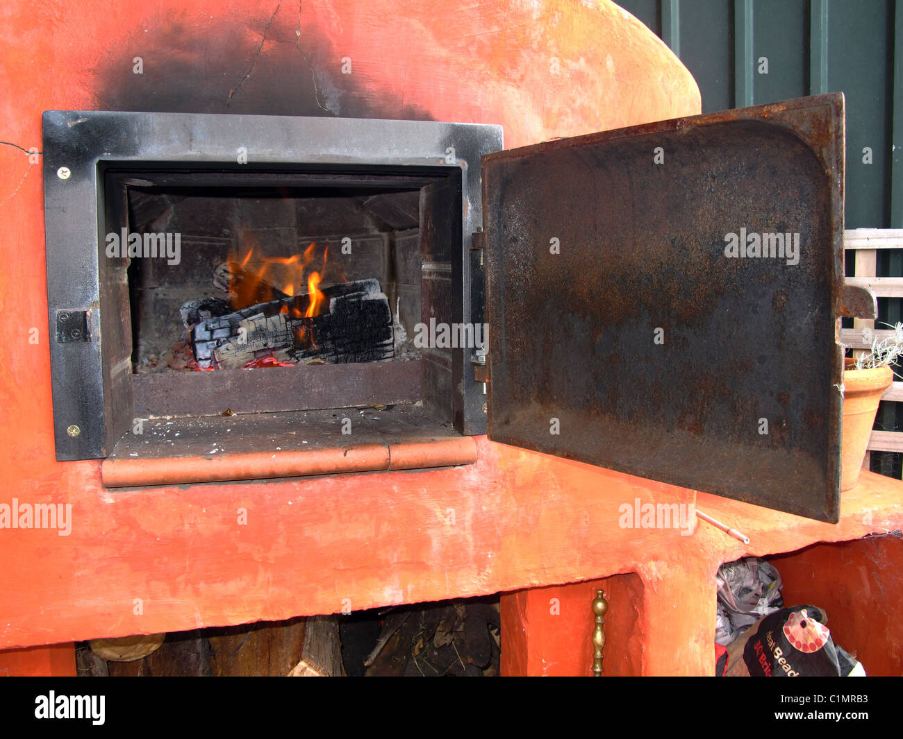 Holzofen mit antiker eiserner Ofentür Stockfoto