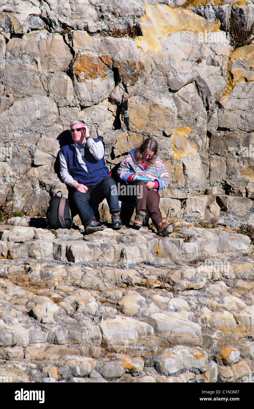 Zwei Wanderer die Erholung bei Tilly Laune Höhlen, Durlston, Dorset UK Stockfoto