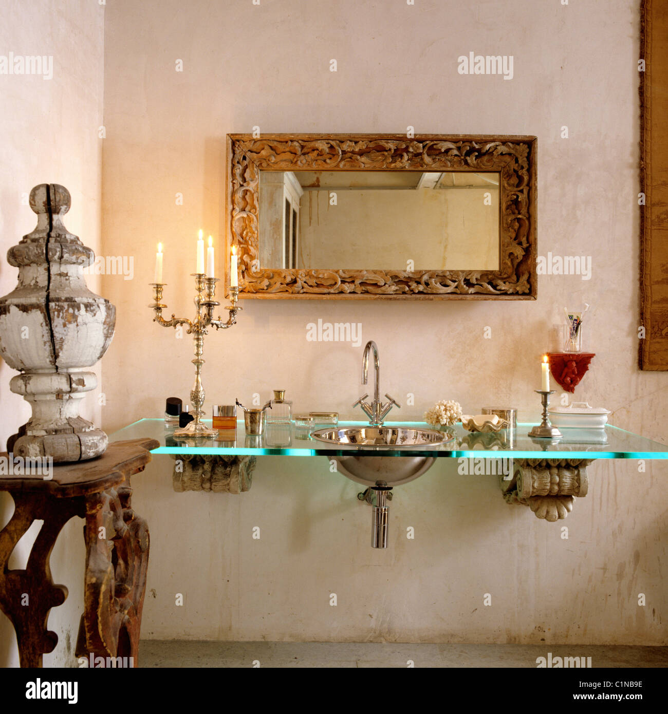 Spülbecken Sie mit Glas-Arbeitsplatte in Wohnung mit unfertigen Stuckarbeiten und Antiquitäten Stockfoto