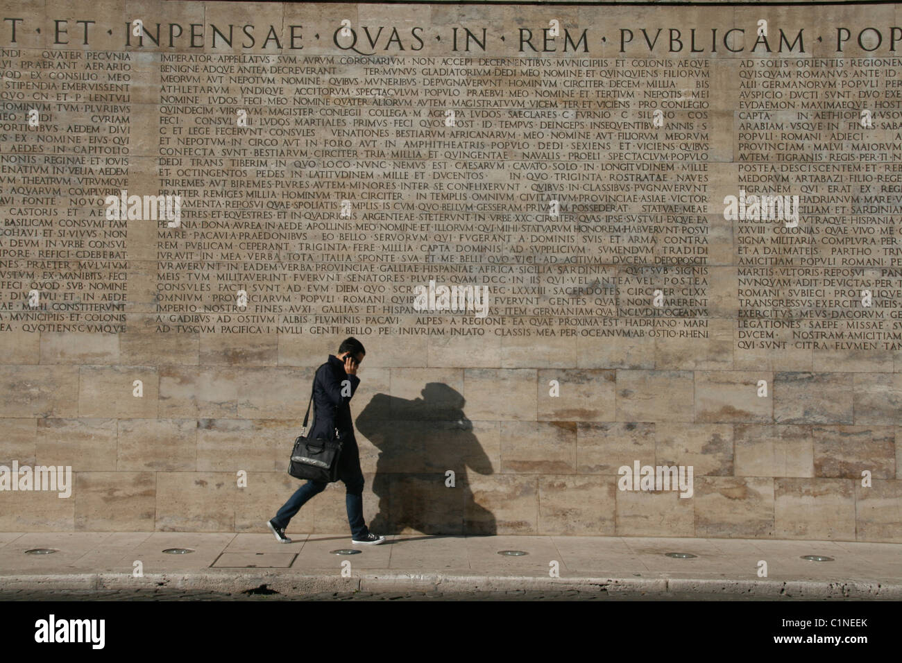 junger Mann durch die lateinische Inschrift auf der Ara Pacis Denkmal in Rom Stockfoto