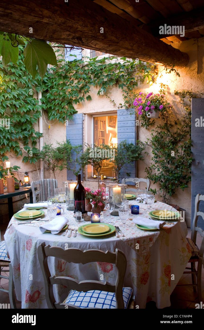 Abendessen im Innenhof des provenzalischen Haus mit Fensterläden und Kletterpflanzen gelegt Stockfoto