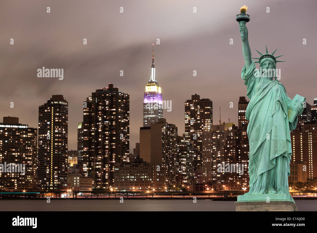 Die Statue of Liberty und Manhattan Skyline bei Nacht, New York City Stockfoto