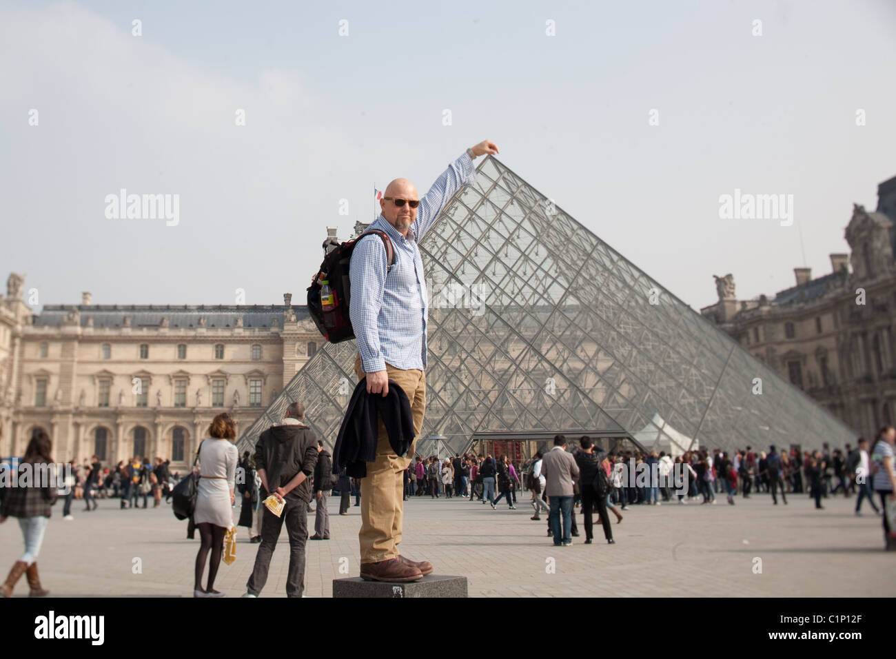 Mann stand außerhalb der Glaspyramide im Louvre Museum in Paris Frankreich Stockfoto