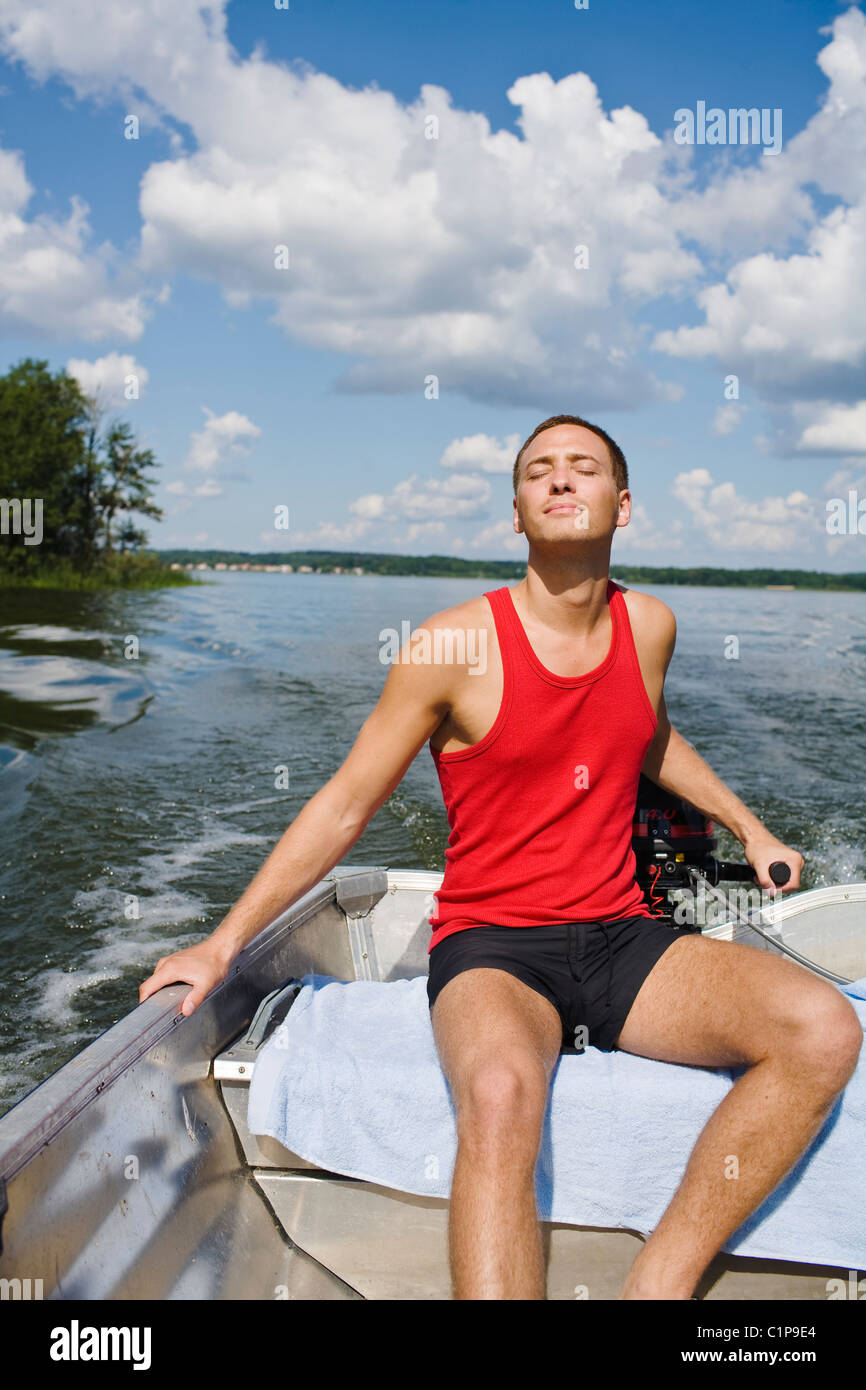 Junger Mann auf Motorboot Stockfoto