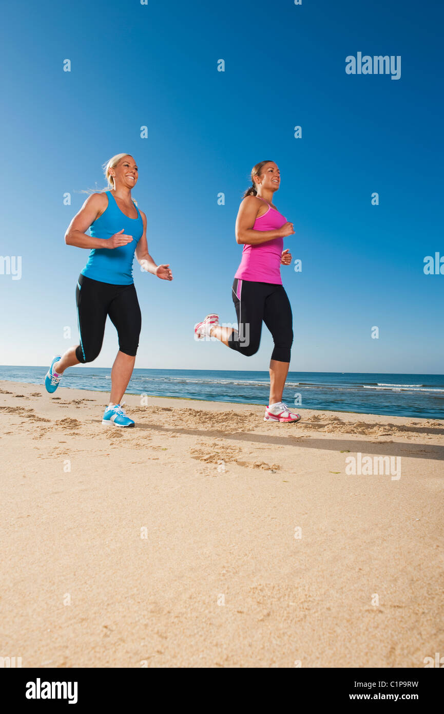 Zwei Frauen am Strand joggen Stockfoto