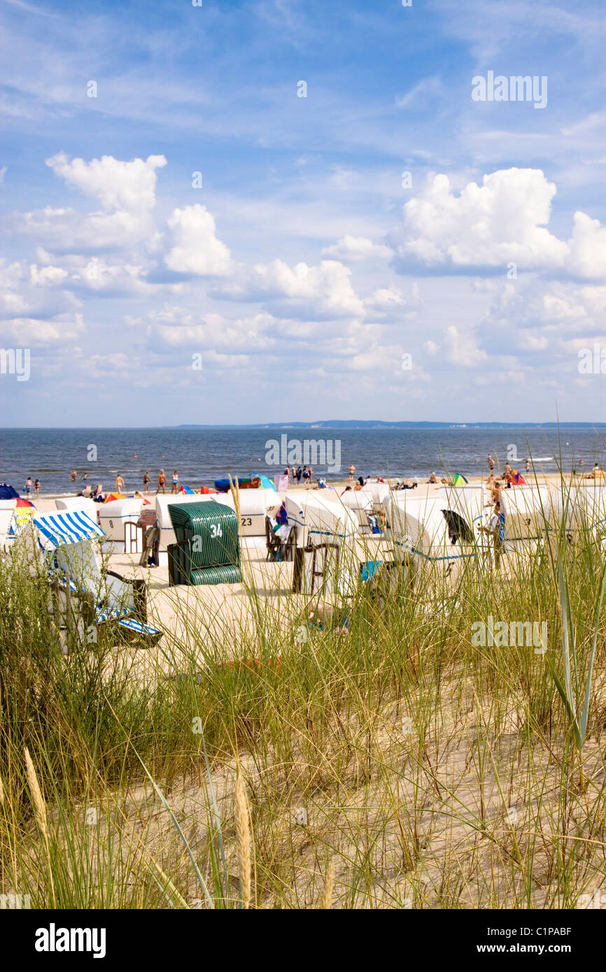 Deutschland, Usedom, Ahlbeck, Bansin, Menschen am Strand mit Kapuzen Strandkörben und Rasen im Vordergrund Stockfoto