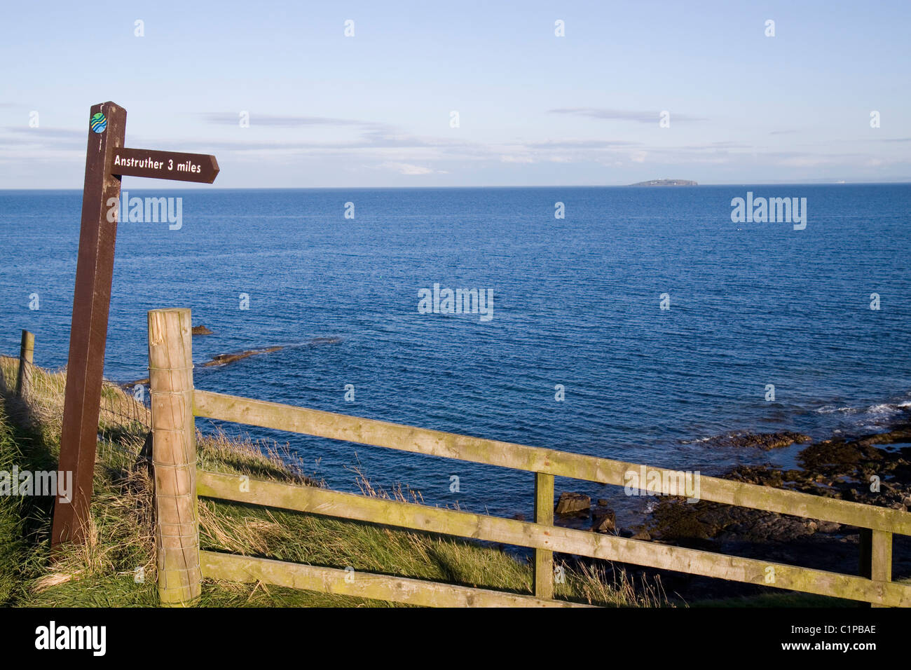 Schottland, Fife, Crail, Wegweiser und Zaun mit Blick auf Meer Stockfoto