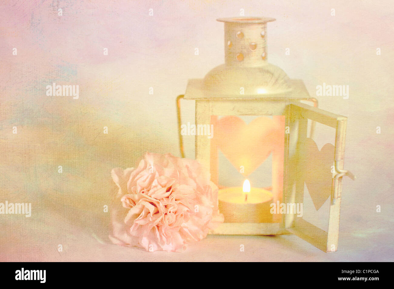 Vintage Creme-Herz-Kerze-Halter mit rosa Blumen und rosa entsättigt strukturierte Hintergrund Stockfoto