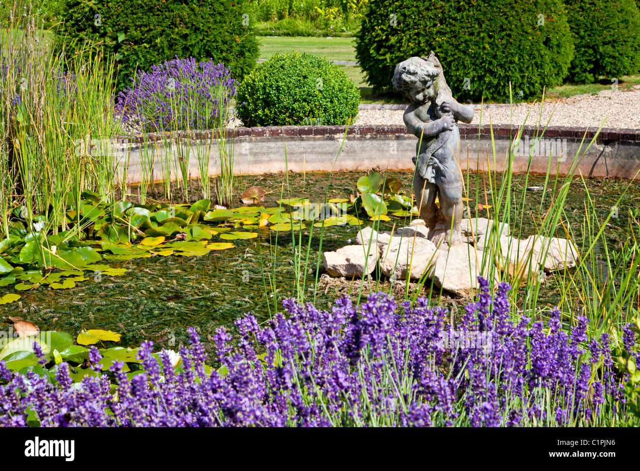 Gartenteich mit Statue und Lavendel in einem englischen Landhaus in