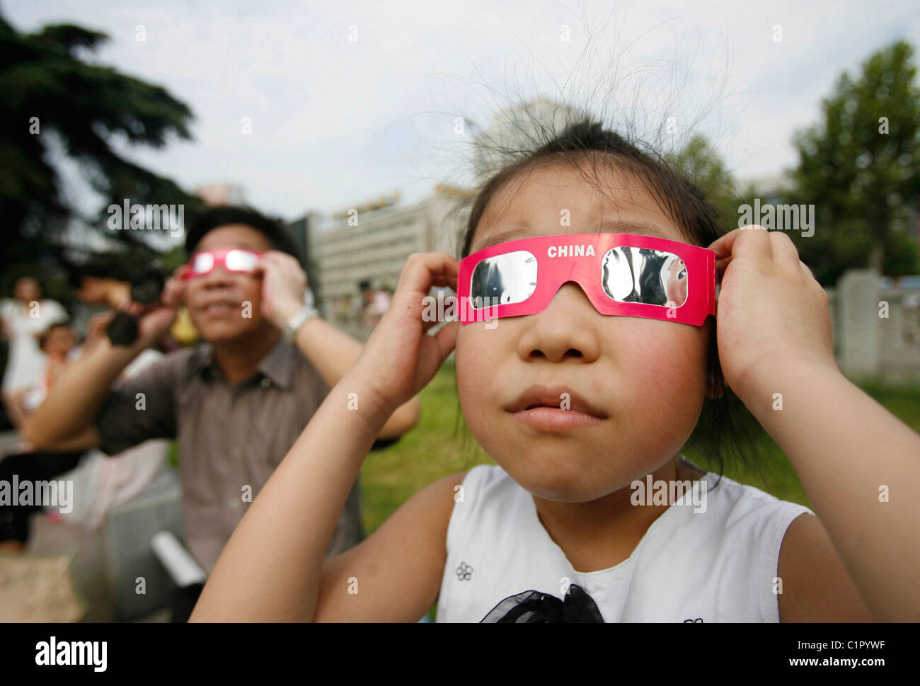 Ein junges Mädchen trägt solar Schutzbrille um die