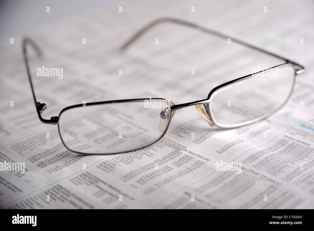 Brille vor dem Hintergrund von Wertpapieren und Aktien Stockfoto