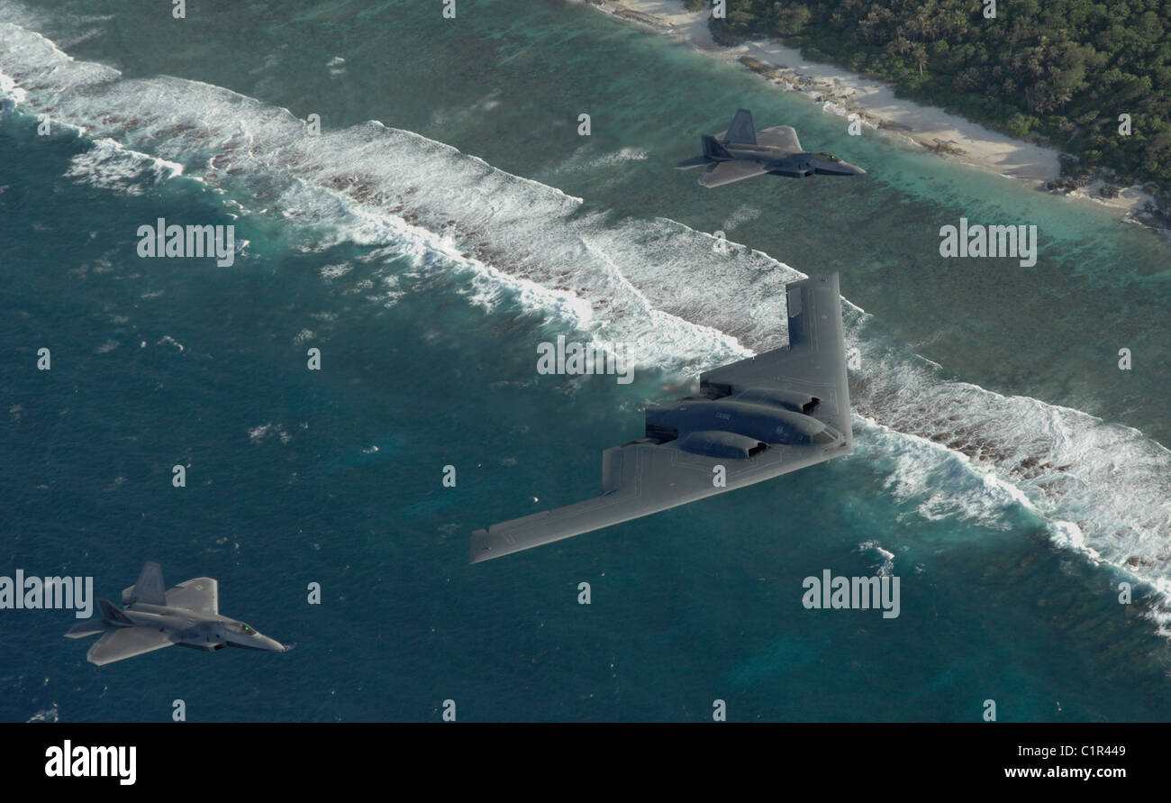 Zwei f-22 Raptor und ein b-2 Spirit Bomber eingesetzt, um Andersen Air Force Base, Guam, fliegen in Formation über dem Pazifischen Ozean. Stockfoto