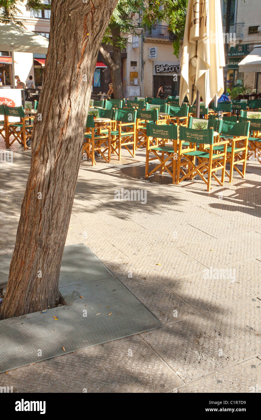 Schattiges Café im Freien in Montpelliers Sommermorgenlicht. Stockfoto