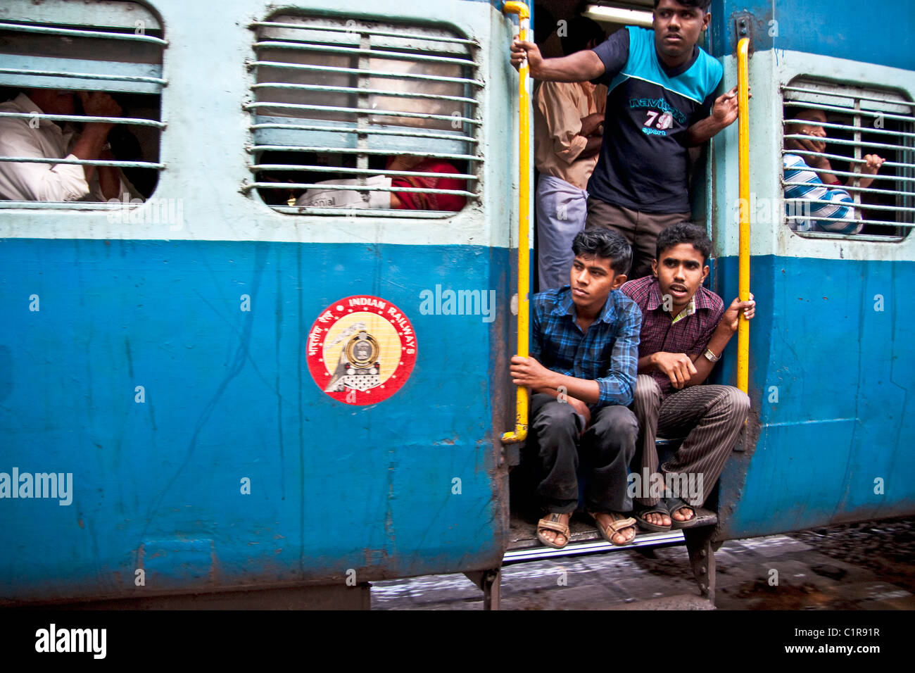 Junge Männer anzeigen Landschaft aus beweglichen intercity Indian Railways Passagier Zug in Kerala. Stockfoto